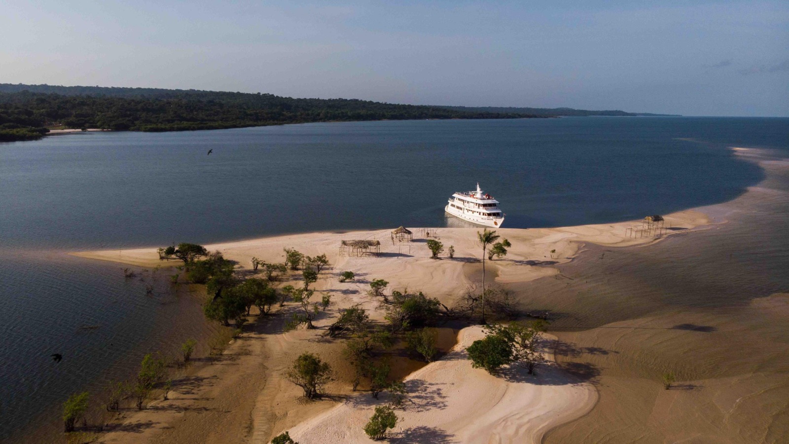 Comunidade ribeirinha com casas palafitas e barcos coloridos
